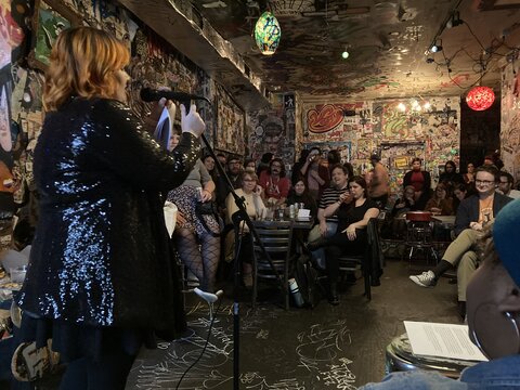 An MFA student reading their work to an audience