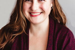 Dr. McDuffie smiles in a burgundy cardigan against a white background. 