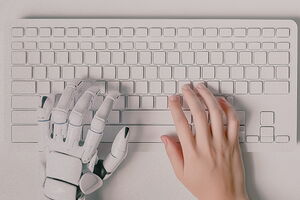 picture of a computer keyboard with a robotic and human hand