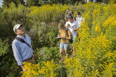 Kanter with students in a field