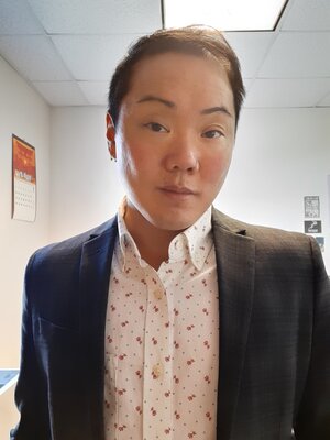 Cassinelli is wearing a white collared shirt with red flowers and blue dots and a dark navy blazer.