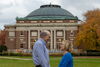 Jean and Steve Kaplan hold hands in front of Foellinger Auditorium